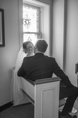 A sequence of someone looking out a window in an empty room with white walls, shot in black and white.