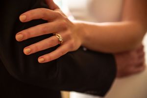 Close-up detail of wedding rings and hands during a ceremony.