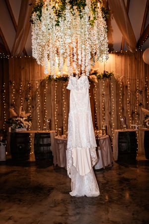 Wedding venue decorated with cascading floral arrangements and twinkling lights in a rustic barn setting.
