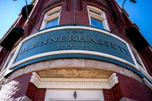 Historic Hotel Massasoit building exterior with ornate brick facade and signage against bright blue sky.