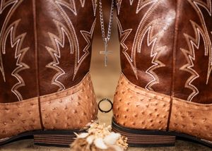 Close-up detail of brown leather cowboy boots with intricate stitching patterns.