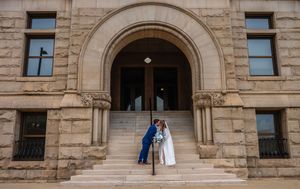 Exterior view of a grand stone building with arched doorways and classic architecture.