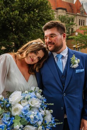 Romantic wedding portraits featuring blue and white floral bouquet and navy blue suit details.