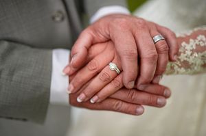 Close-up of newlyweds' hands showing wedding rings during ceremony.