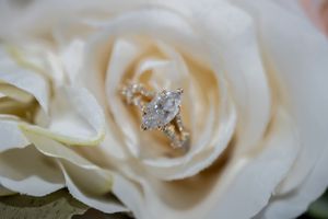 Close-up view of delicate white roses with glittering diamond accents creating an elegant wedding detail.