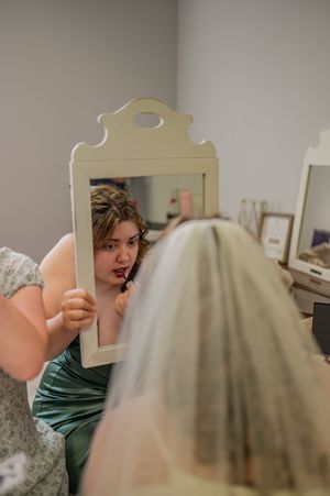 A mirror reflection captures preparations before the wedding ceremony.
