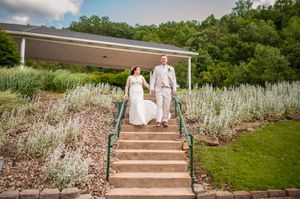 Couple walking down outdoor stone steps surrounded by landscaped garden.