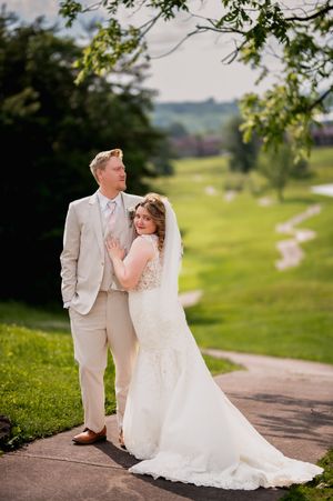 A romantic wedding portrait on a path overlooking rolling hills and countryside.