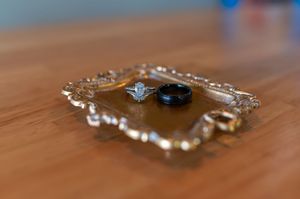 Wedding rings displayed on ornate crystal tray with elegant details.
