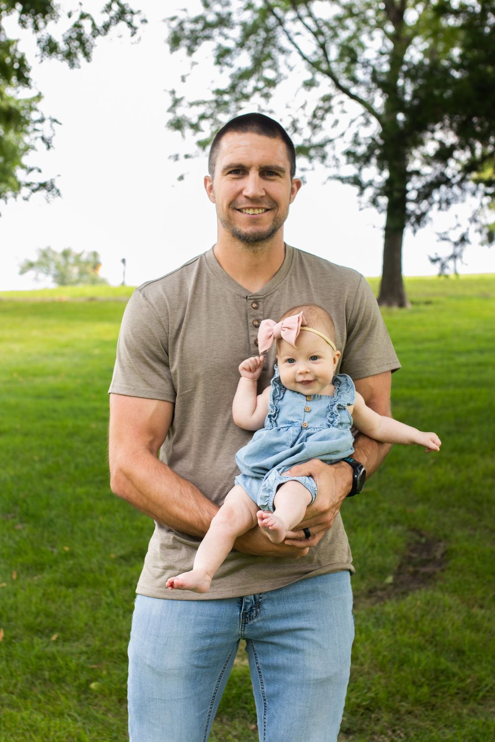 Parent and baby sharing joyful moments in park setting.