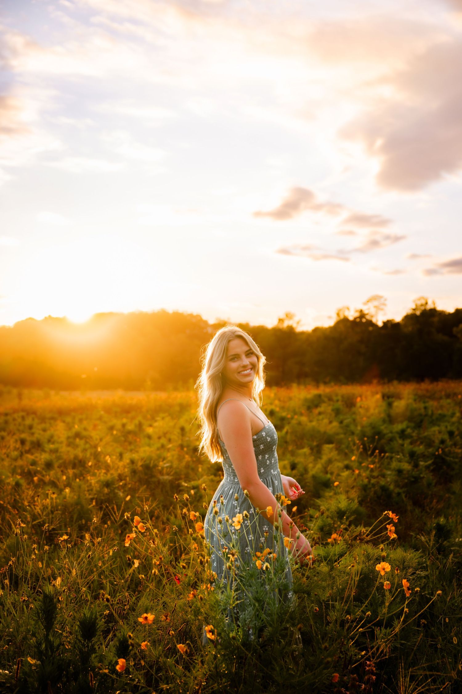 A floral dress flows in the breeze during a sunset photoshoot in a meadow.