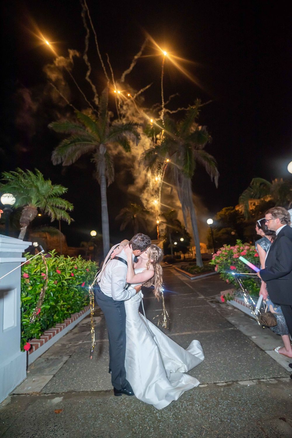 A romantic nighttime scene in a garden setting with illuminated palm trees and street lamps creating a magical atmosphere.