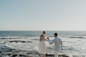 Couple holding hands near the water — alternative elopement photography