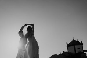 Groom spinning the bride by the sea — candid elopement moment captured in natural light.
