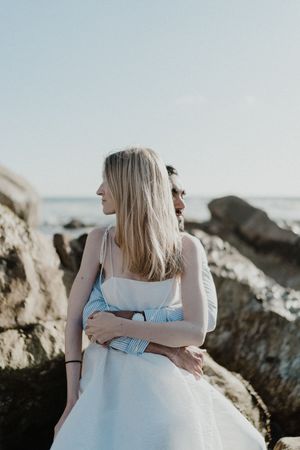 Groom helping bride adjust dress — raw wedding photography in Portugal