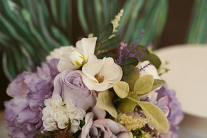 Elegant wedding bouquet with purple hydrangeas, lavender roses, white flowers and green orchids.