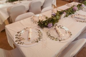 An elegant wedding table setting with greenery garland and mirrored charger plates.