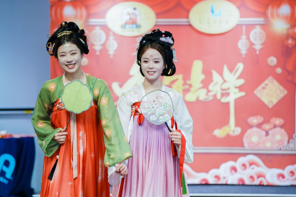 Joyful corporate event photography featuring a group in traditional Hanfu at a company party, by an Auckland event photographer.