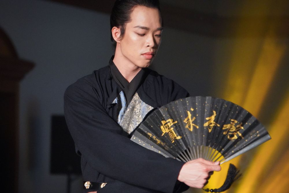 Dramatic stage photography of a traditional Hanfu fashion show featuring elegant performers, by an Auckland event photographer.