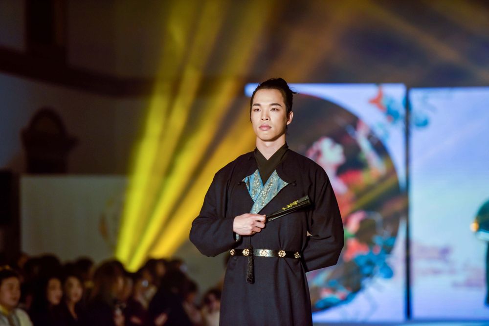 Dramatic stage photography of a traditional Hanfu fashion show featuring elegant performers, by an Auckland event photographer.