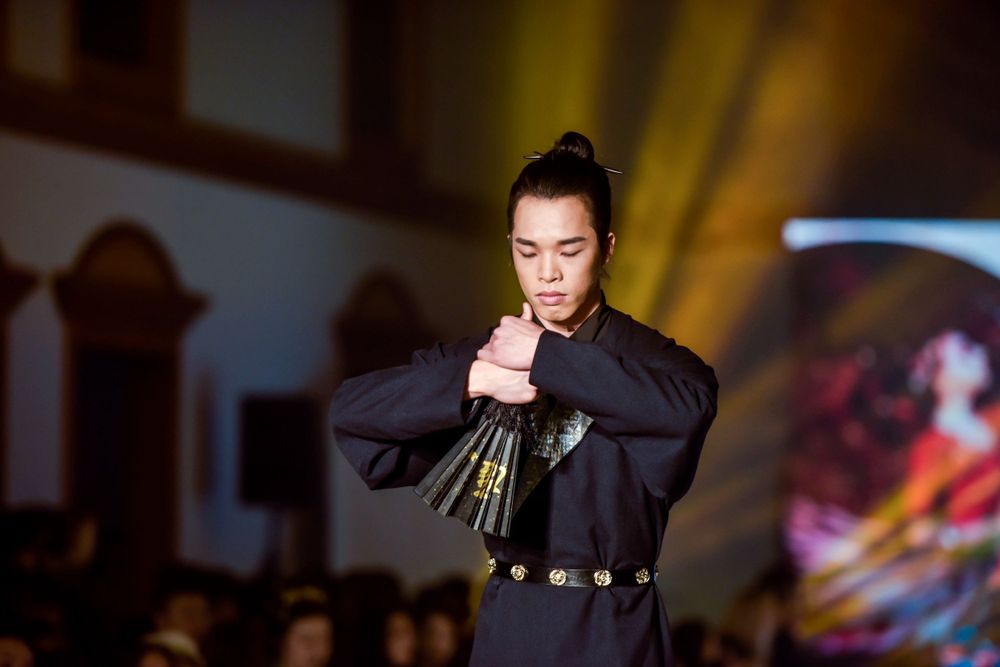 Dramatic stage photography of a traditional Hanfu fashion show featuring elegant performers, by an Auckland event photographer.