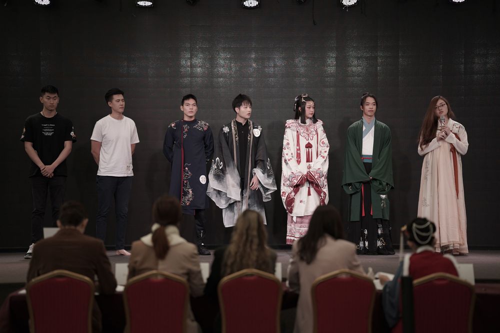 Dramatic stage photography of a traditional Hanfu fashion show featuring elegant performers, by an Auckland event photographer.