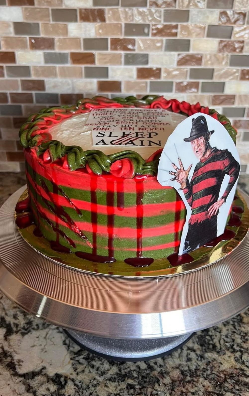 Freddy Krueger themed cake with red and green stripes and horror movie decoration.