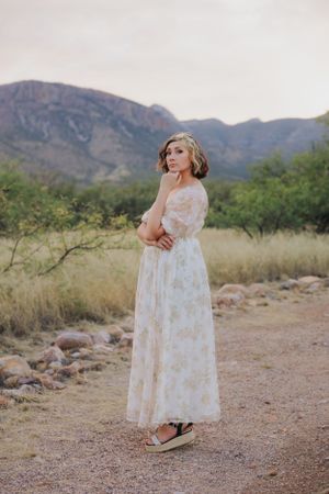 A romantic floral dress stands out against the rustic desert landscape and mountain vista.