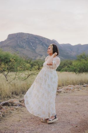 Graceful dance movements in a white dress against scenic desert mountain views.