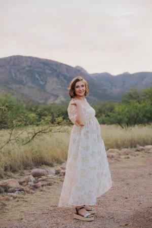 Dancing figure in white dress moves gracefully across desert landscape with mountain backdrop.