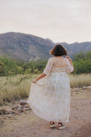Flowing white dress movement photographed against rugged desert mountain terrain.