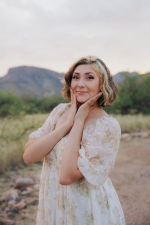 A romantic portrait in a white lace dress with mountains and desert brush in the background.