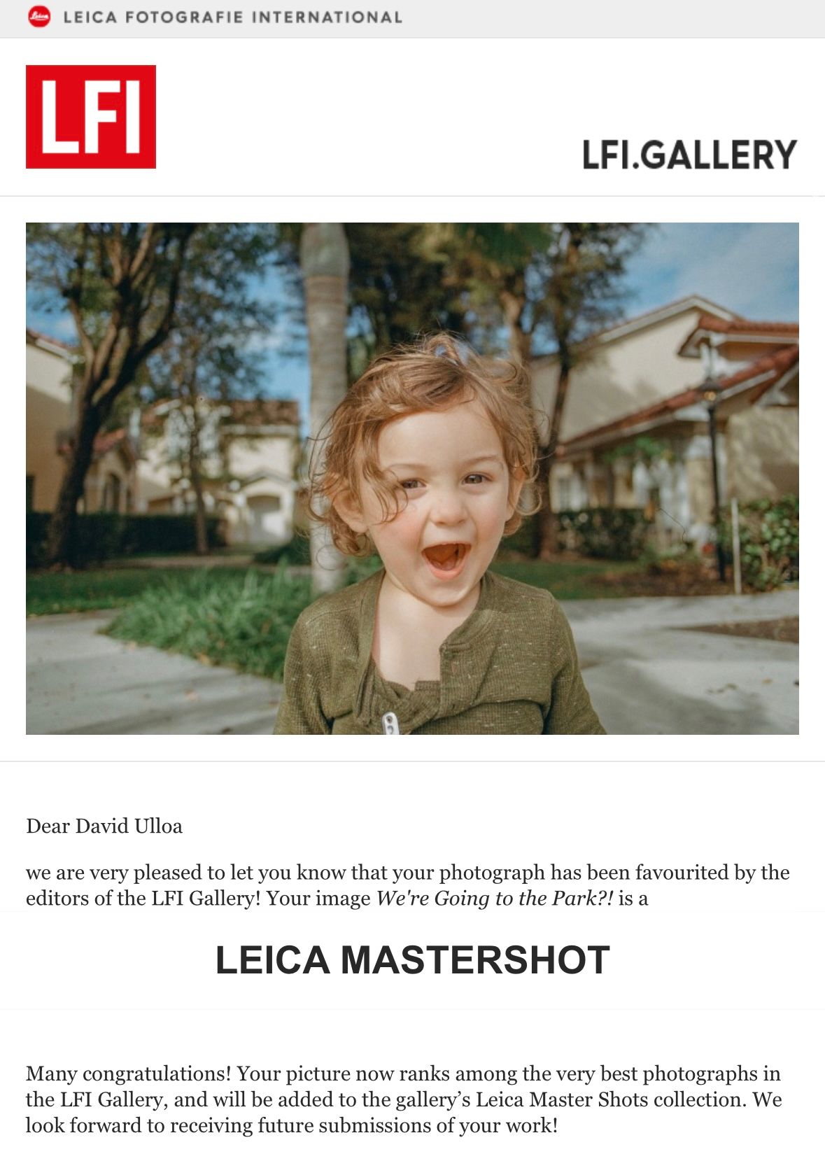 A joyful expression captured outdoors in front of houses with Leica Mastershot award notification.