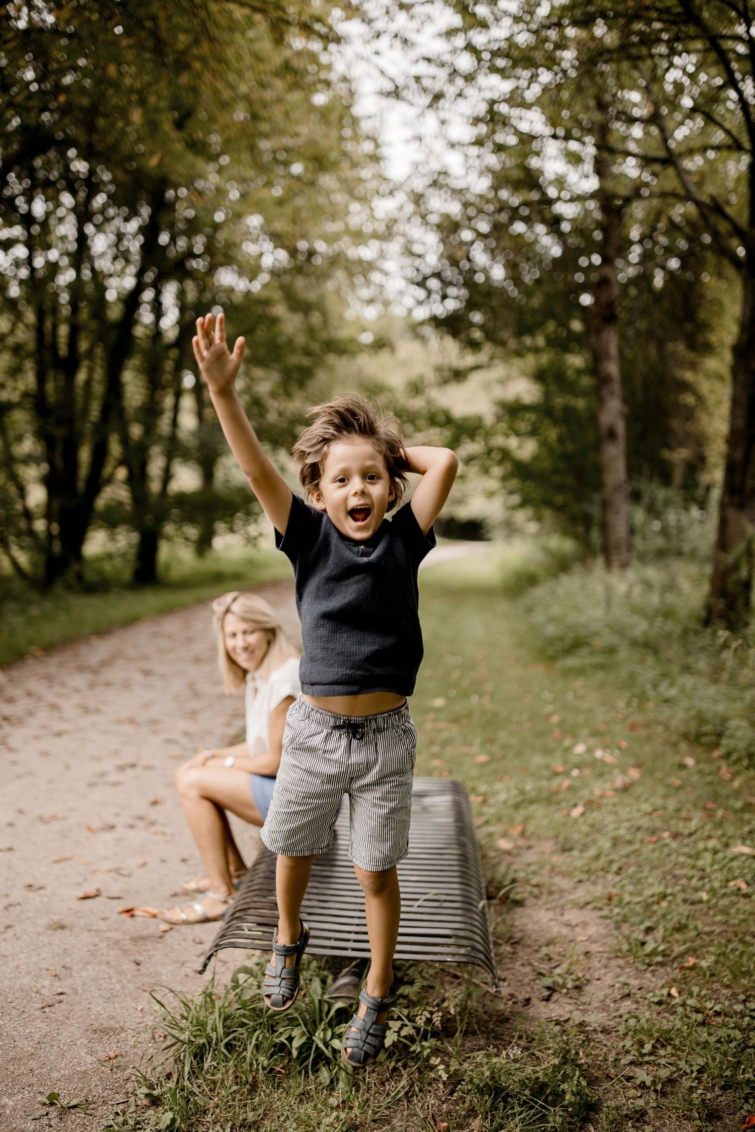 Des enfants jouent et sautent avec enthousiasme sur un sentier naturel.
