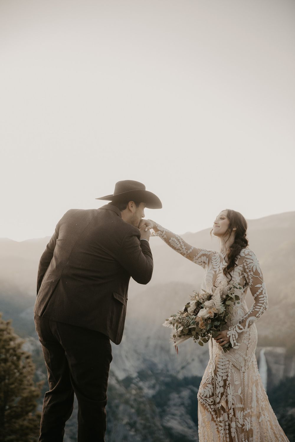 Intimate wedding portraits captured on a mountaintop with dramatic landscape views in the background.