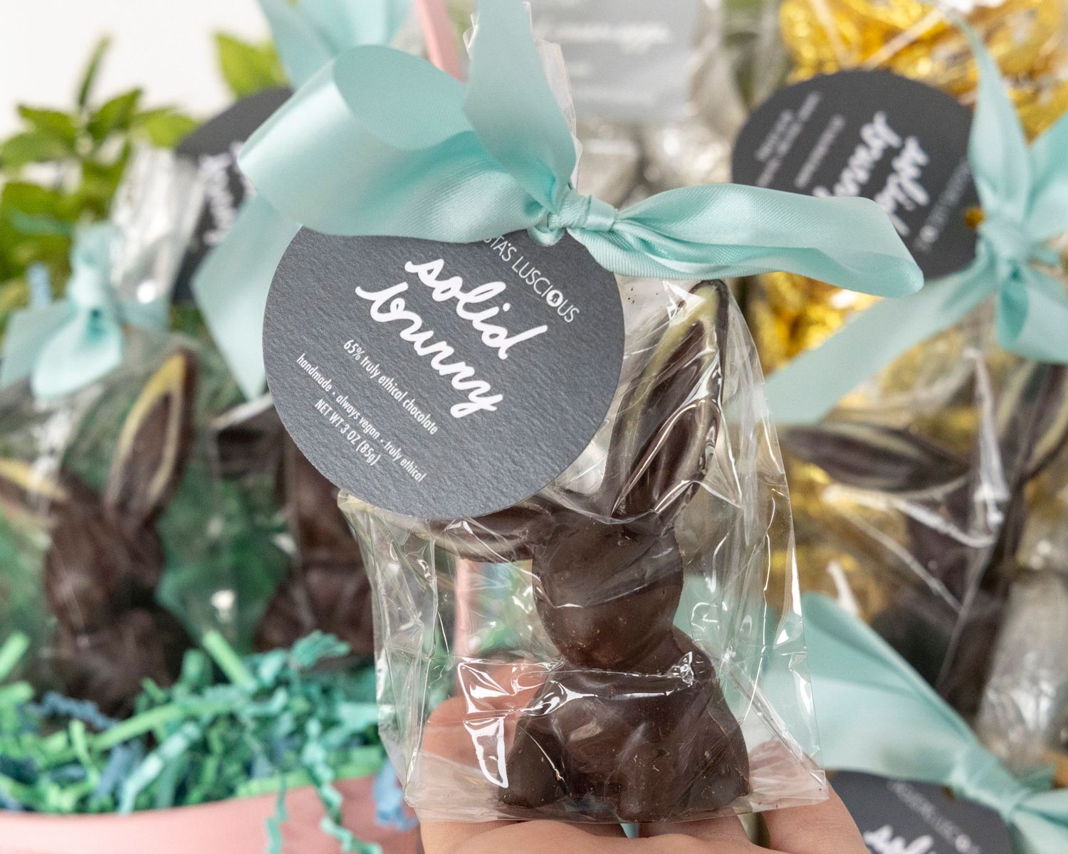 Handmade dark chocolate truffles wrapped in clear cellophane with mint-colored ribbons and gift tags.