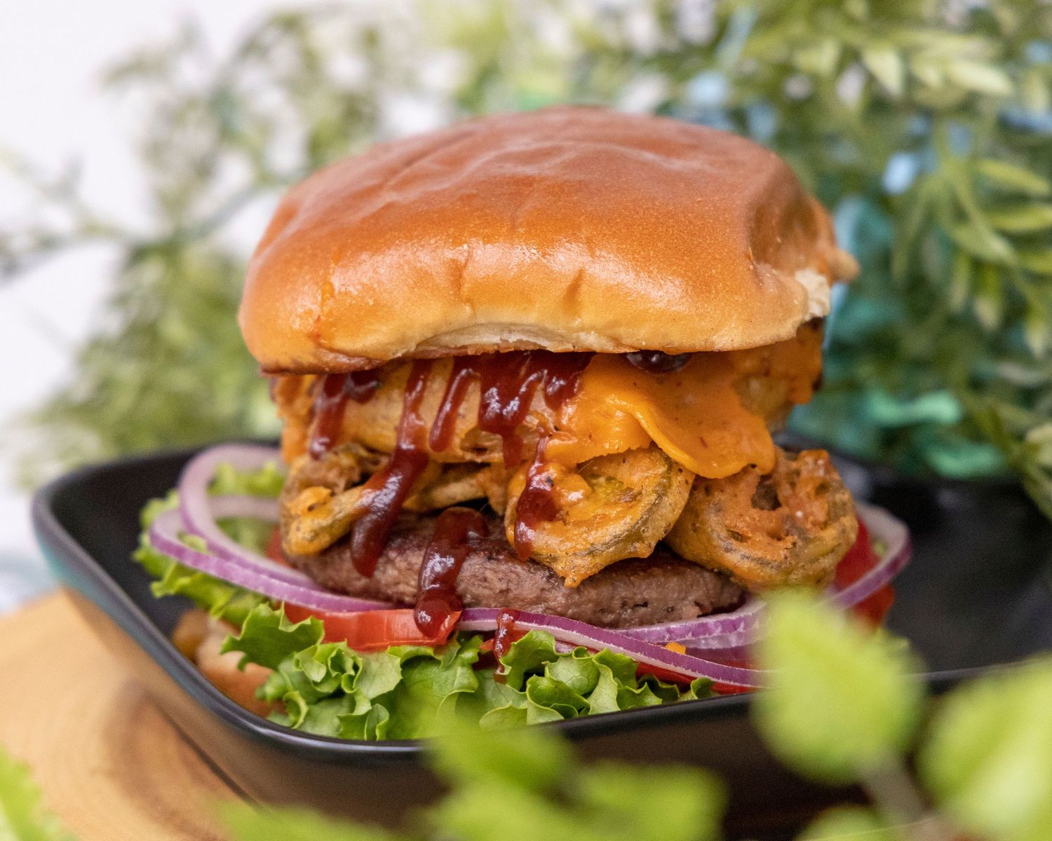 Juicy hamburger with melted cheese, fresh lettuce, red onions and bacon on a toasted brioche bun.