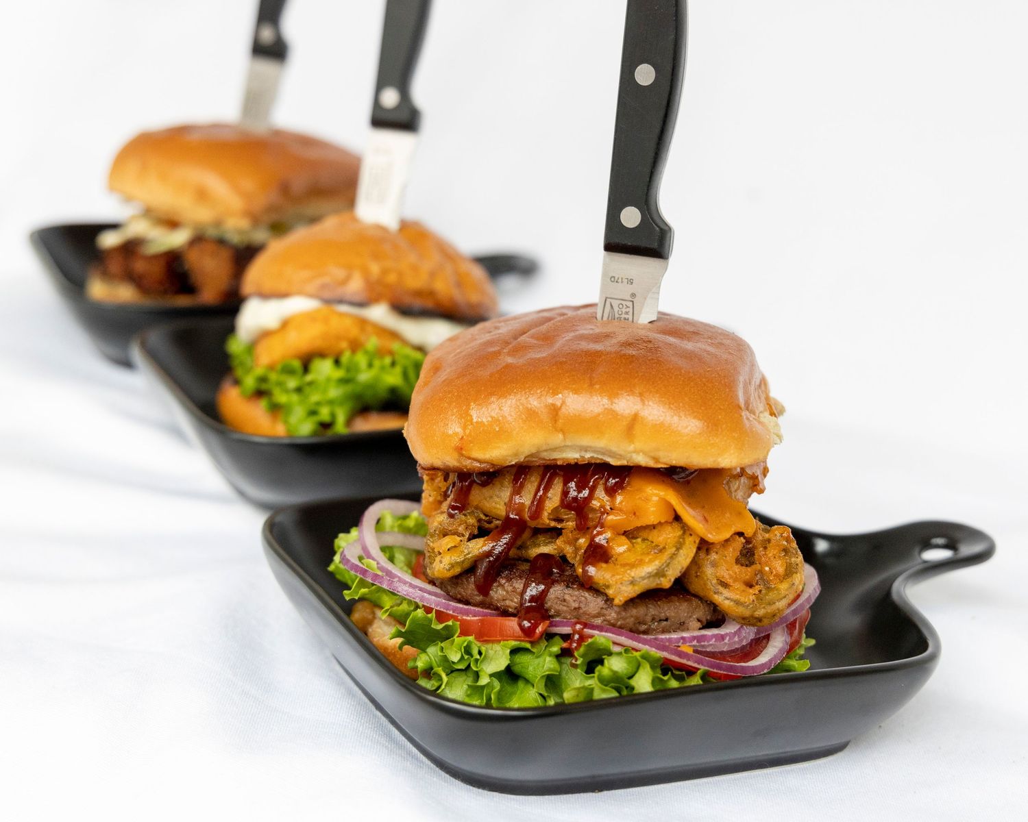 Black iron skillet filled with juicy cheeseburger topped with lettuce and served on a bun.