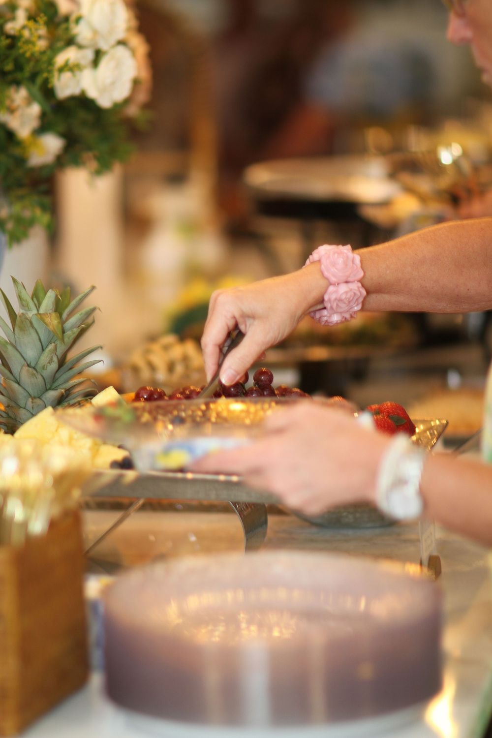 Close-up of various appetizers and decorative elements being arranged on a table at an elegant event setting.