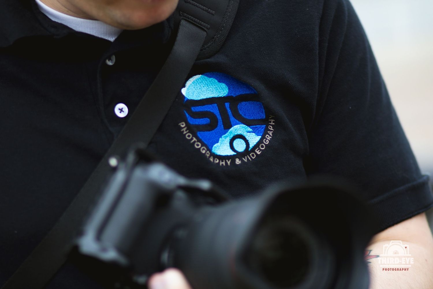 A holographic STC logo sticker displayed on a black surface against a dark background.