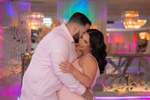 Couple sharing a romantic embrace on the dance floor at a beautifully decorated baby shower event.