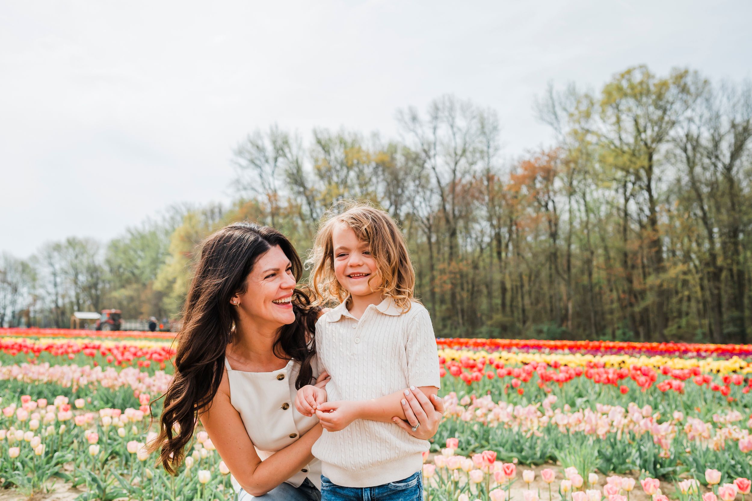 Joyful moment shared between two people in a blooming tulip field on a bright spring day.