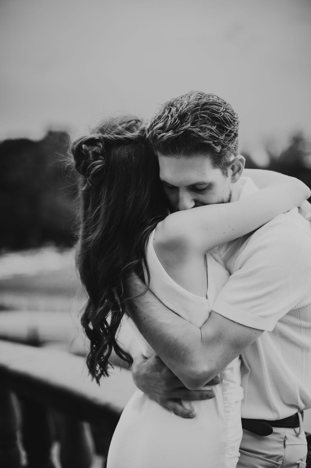 Black and white romantic portrait of a couple embracing and kissing at The Felt Estate