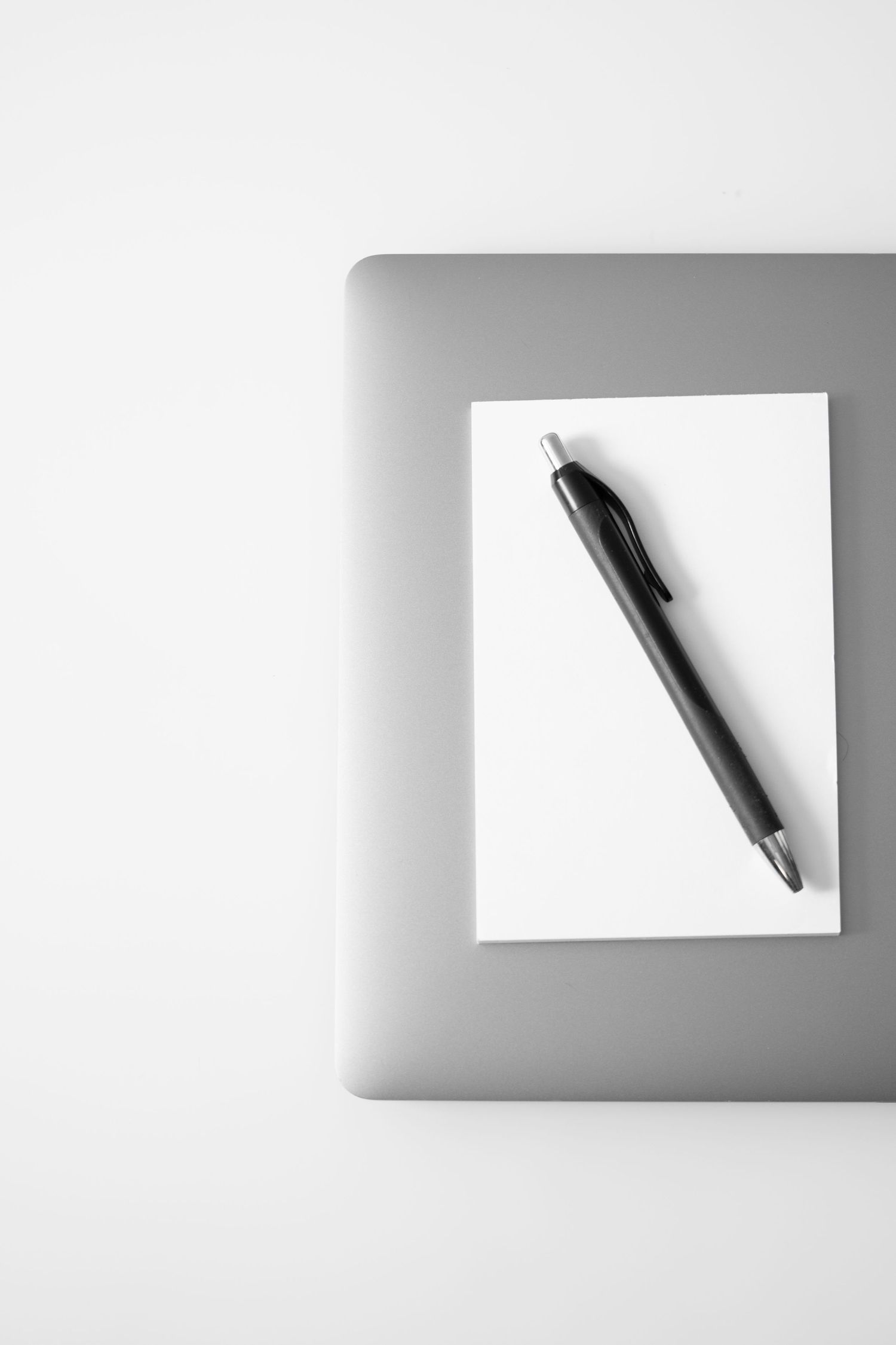 Super clean branding photo for use in blogging, backdrops and more. A desk, a laptop, a pad of paper and a pen.