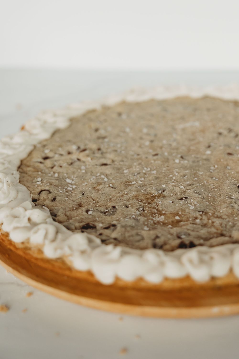 A homemade cream pie with a dark chocolate or cookie filling and whipped cream border on a glass pie plate.