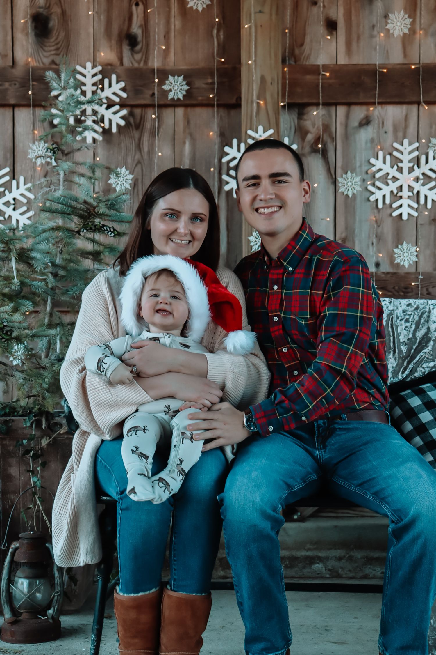 Holiday family portrait with snowflake decorations against rustic wooden backdrop.