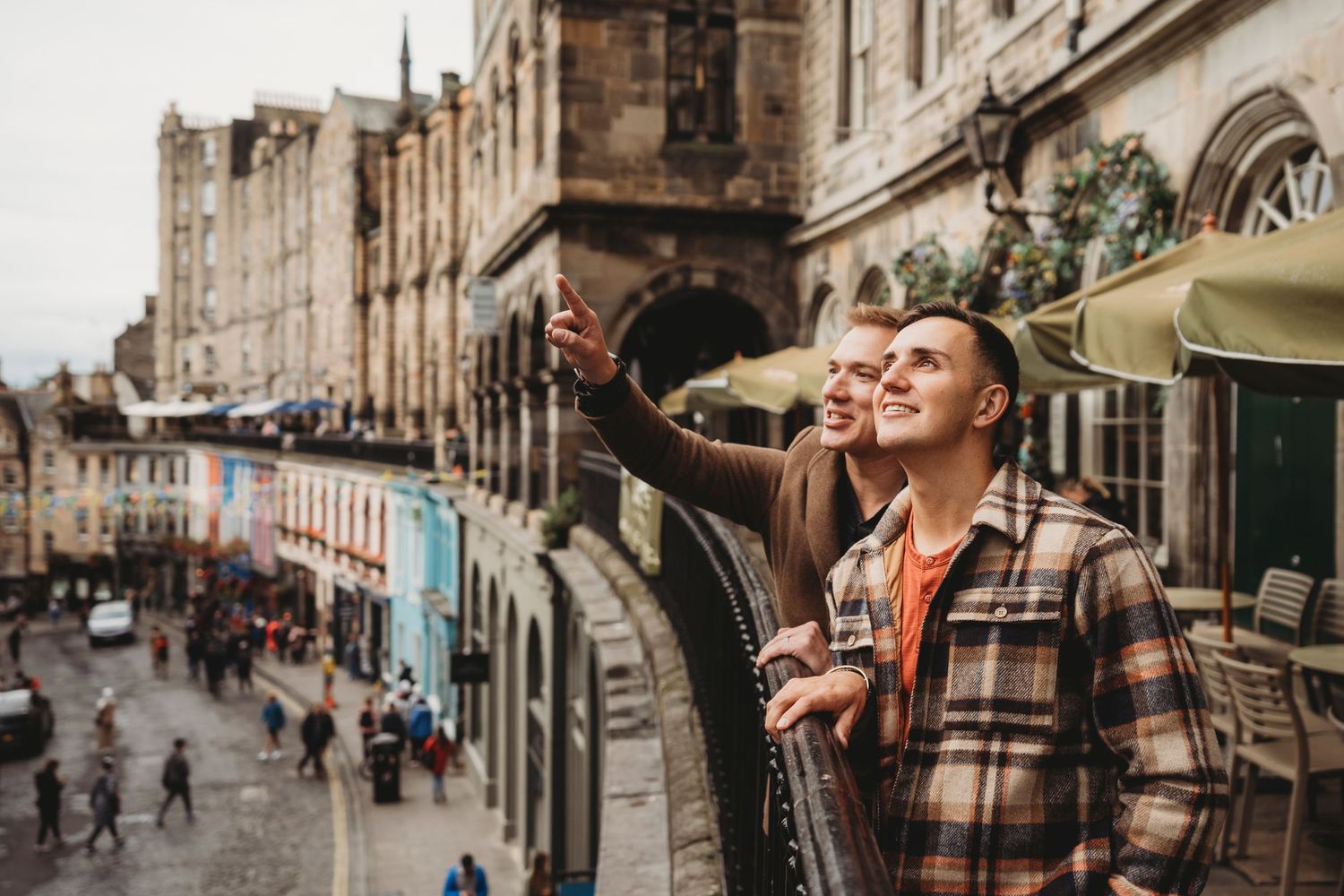 People enjoying a scenic view from a historic street balcony in Edinburgh.