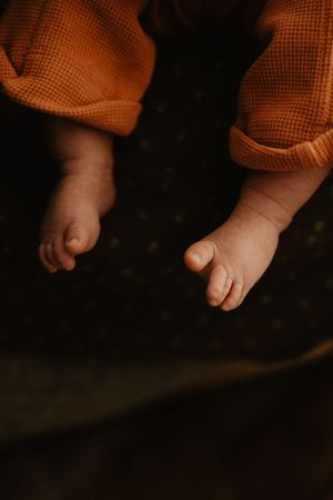 Artistic series of small feet and toes in warm, moody lighting.