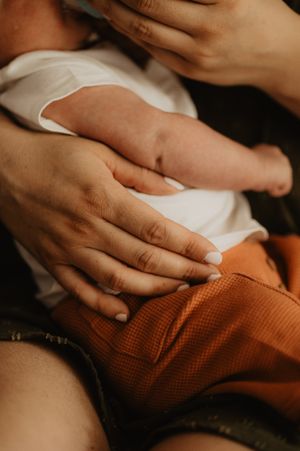 Close-up shots of gentle hands resting on textured orange fabric.