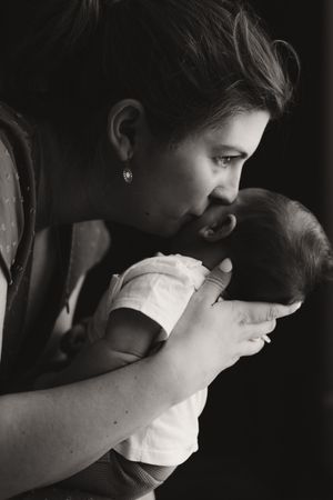 Black and white series capturing intimate nurturing moments in dramatic lighting.